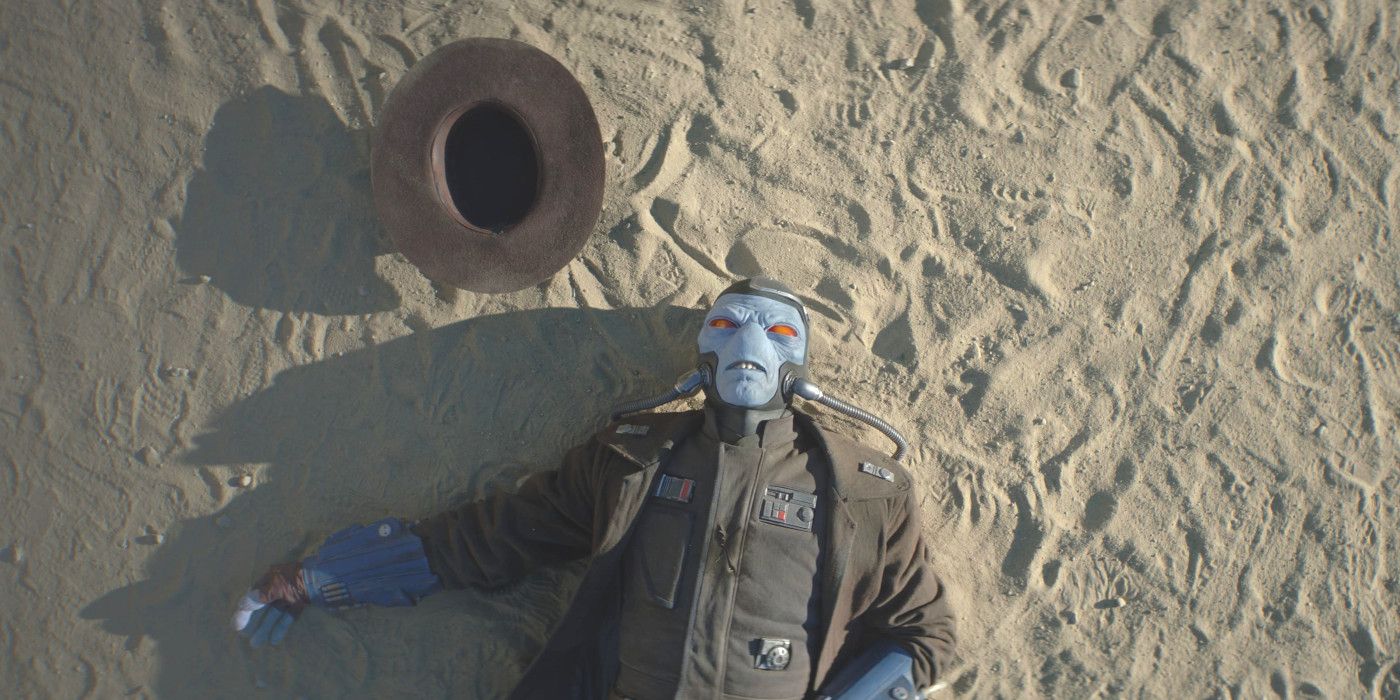 Cad Bane no Livro de Boba Fett deitado na areia com o chapéu fora da cabeça, aparentemente morto