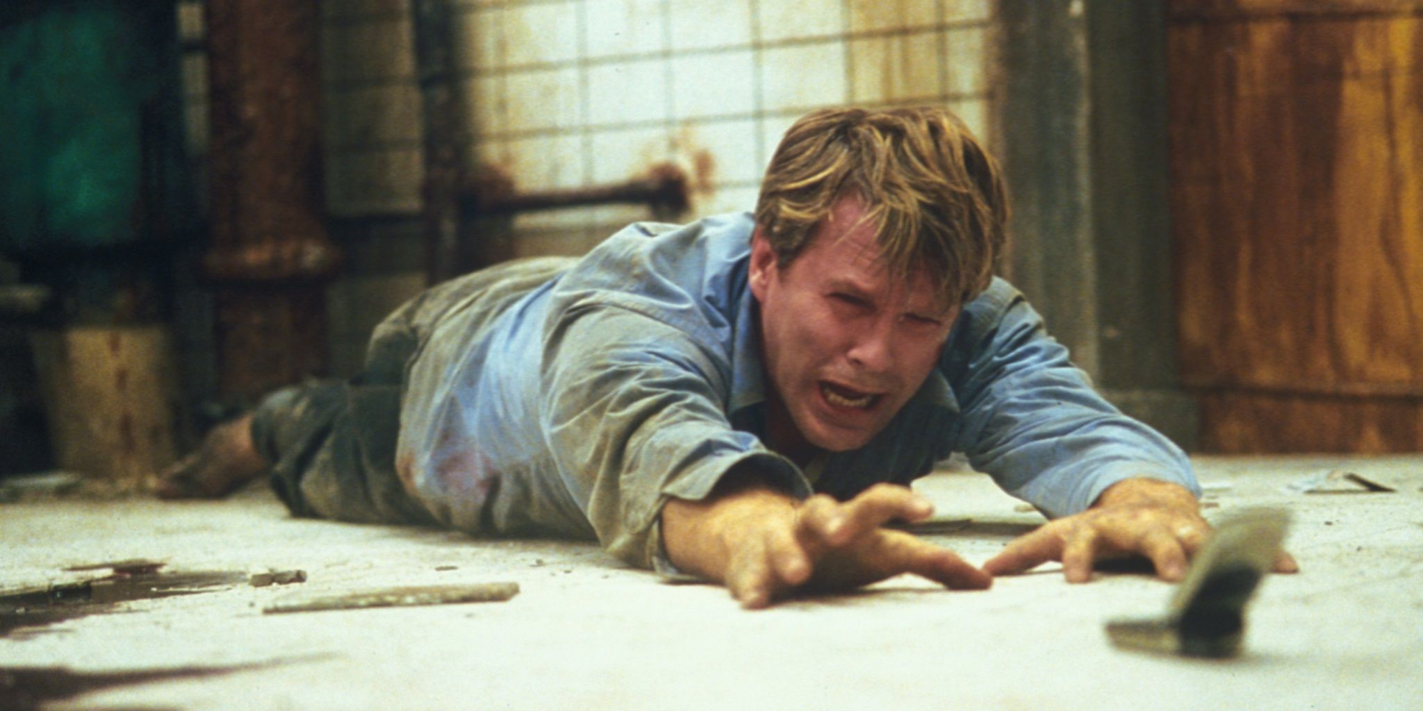 Cary Elwes reaches for a phone in Saw