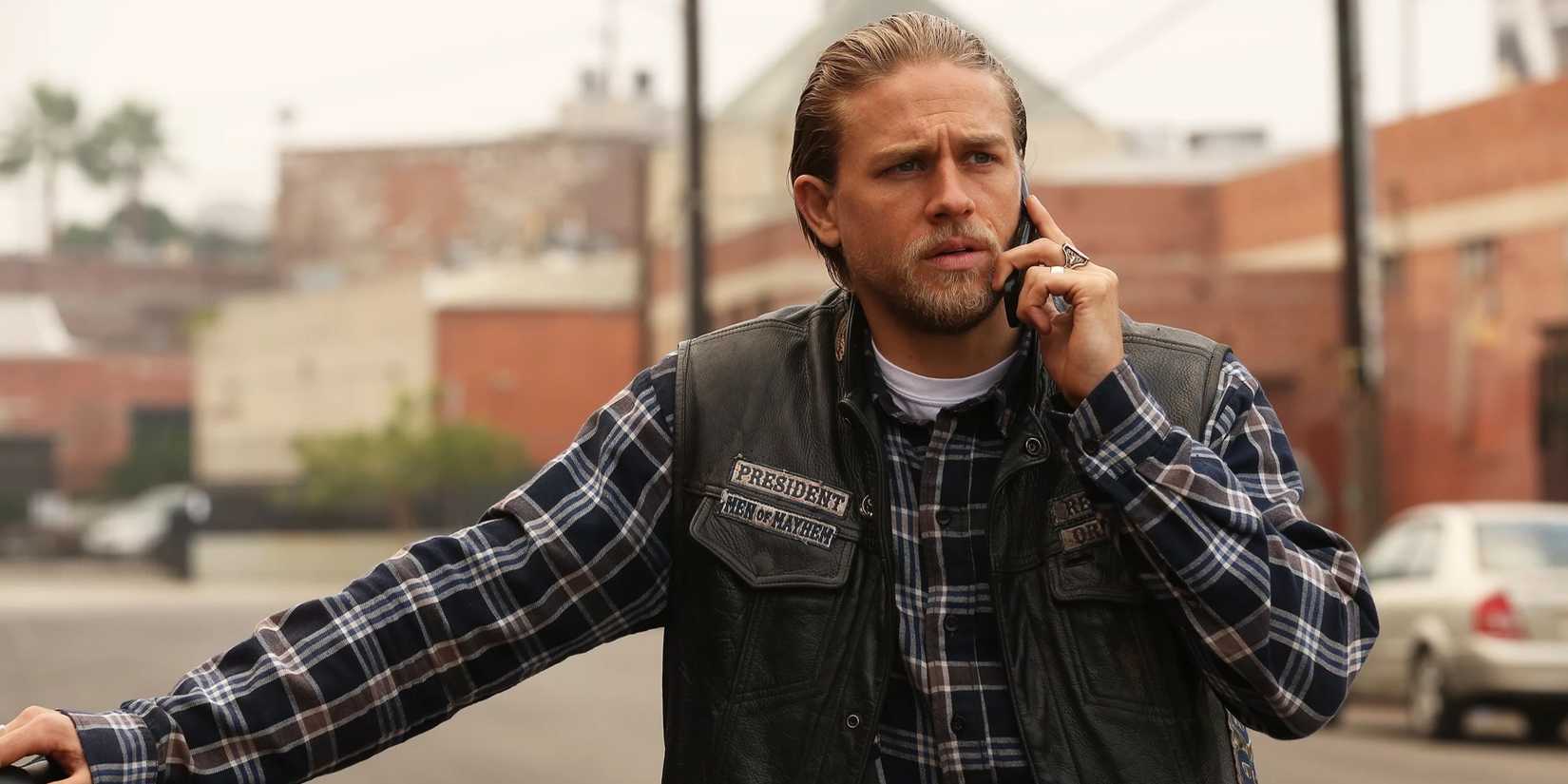 Charlie Hunnam as Jax Teller on Sons of Anarchy leaning against something while talking on the phone (2008-2014)