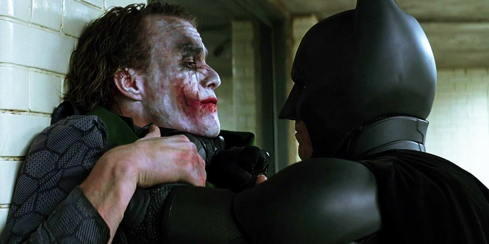 Christian Bale as Batman holding Heath Ledger's Joker against wall in The Dark Knight