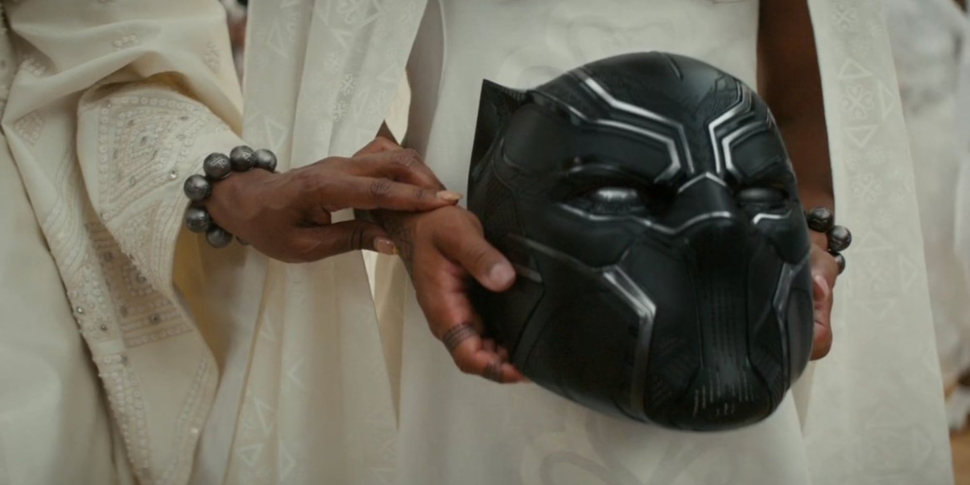 Shuri holds T'Challa's Black Panther helmet in Wakanda Forever.