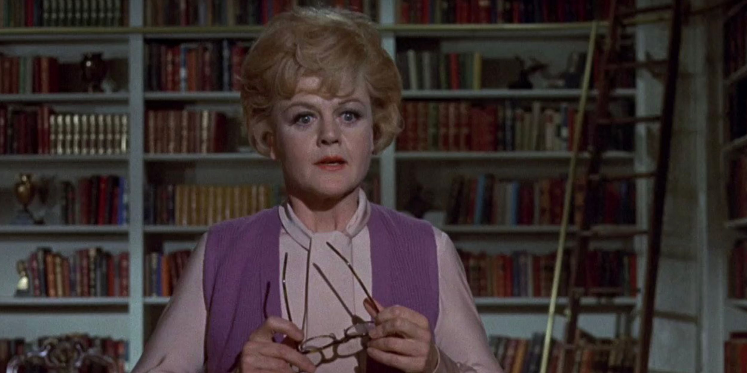 Eglantine Prince holding her glasses in a library in Bedknobs and Broomsticks