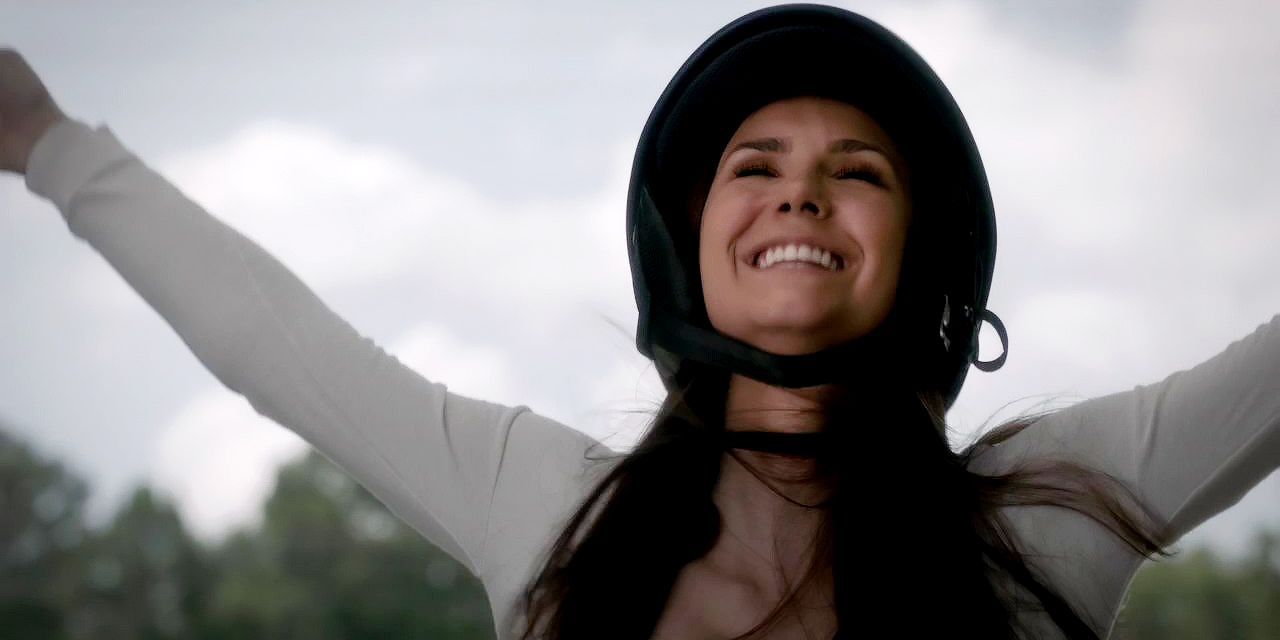 Elena standing on top of a motorcycle and having fun on The Vampire Diaries
