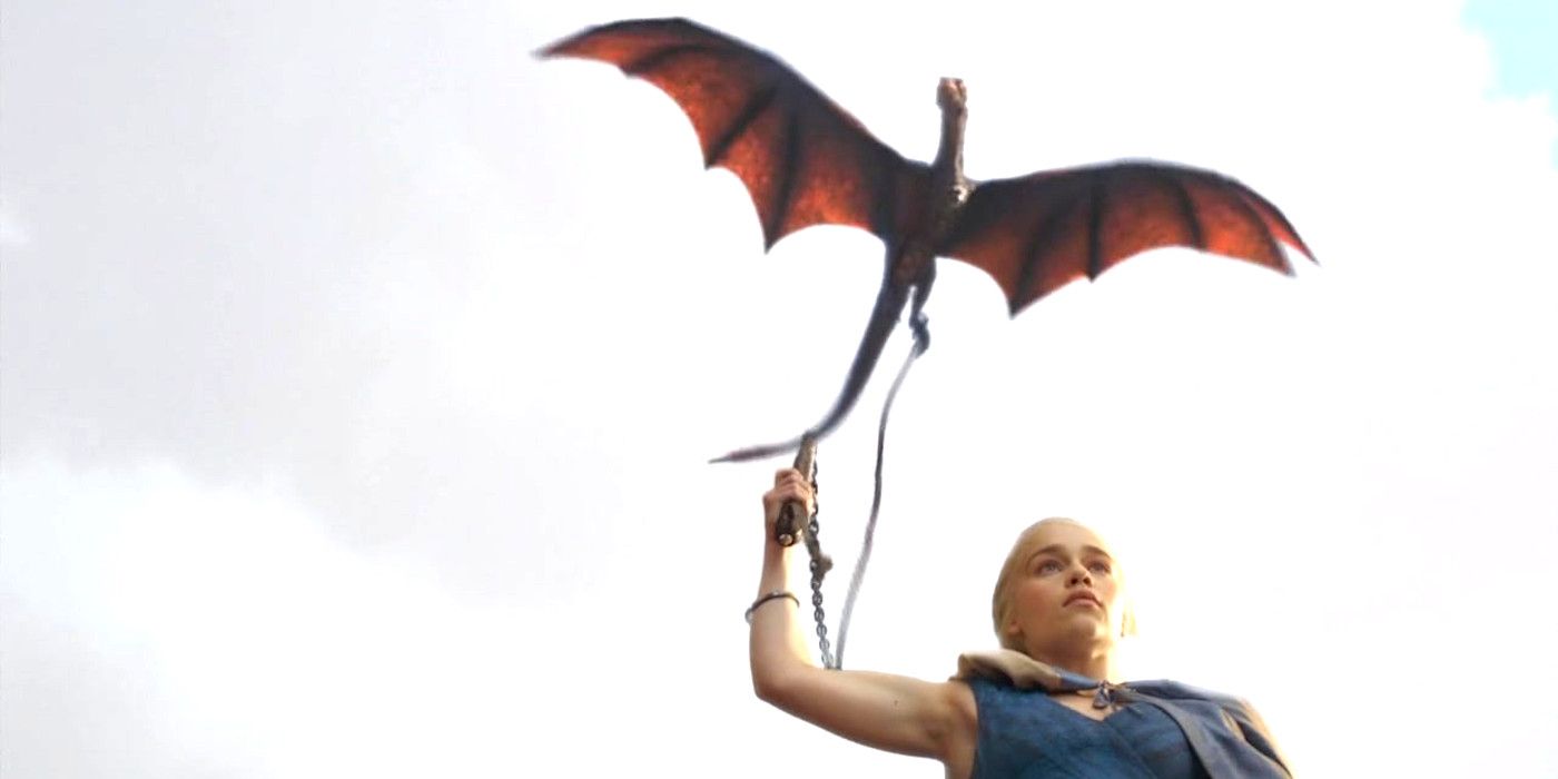 Emilia Clarke as Daenerys in Game of Thrones with a leashed dragon soaring above her head