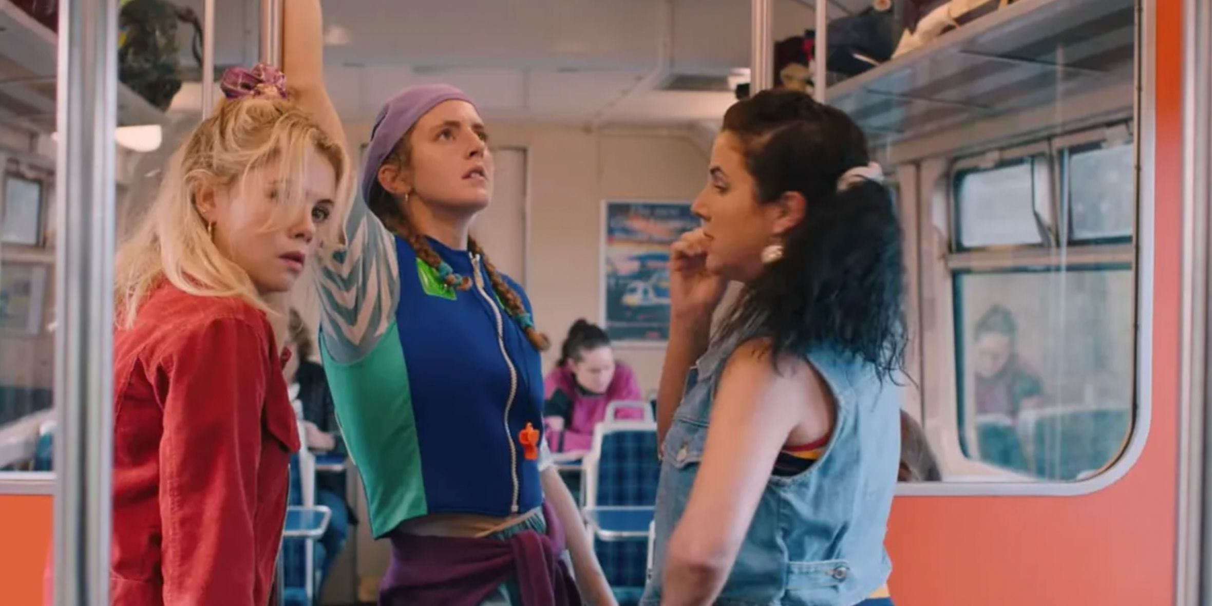 Erin, Orla, and Michelle standing on a train in Derry Girls Season 3