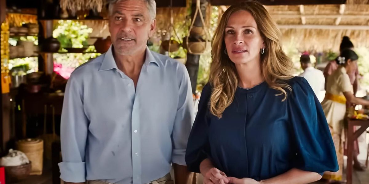 George Clooney and Julia Roberts standing next to each other with black expressions in Ticket To Paradise