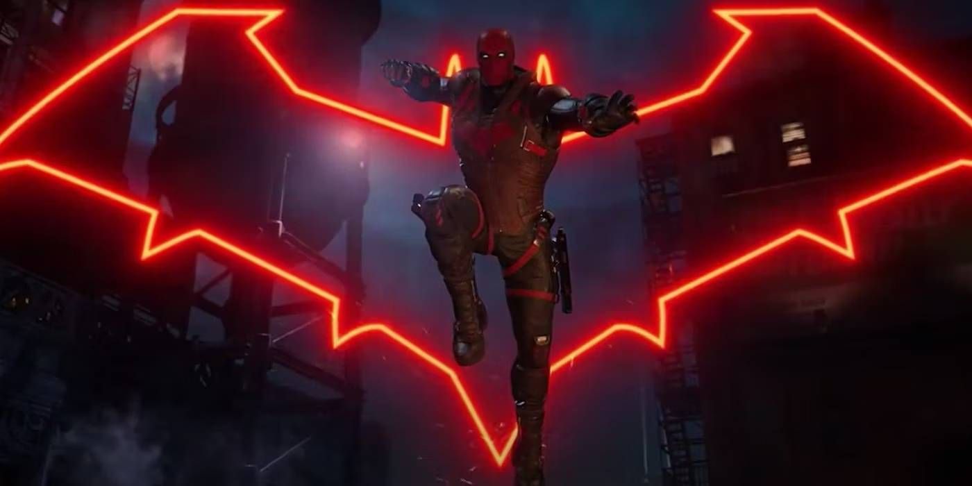 Capuz Vermelho dos Cavaleiros de Gotham com Símbolo em Pose de Ação da Captura de Tela Cinematográfica do Trailer Principal