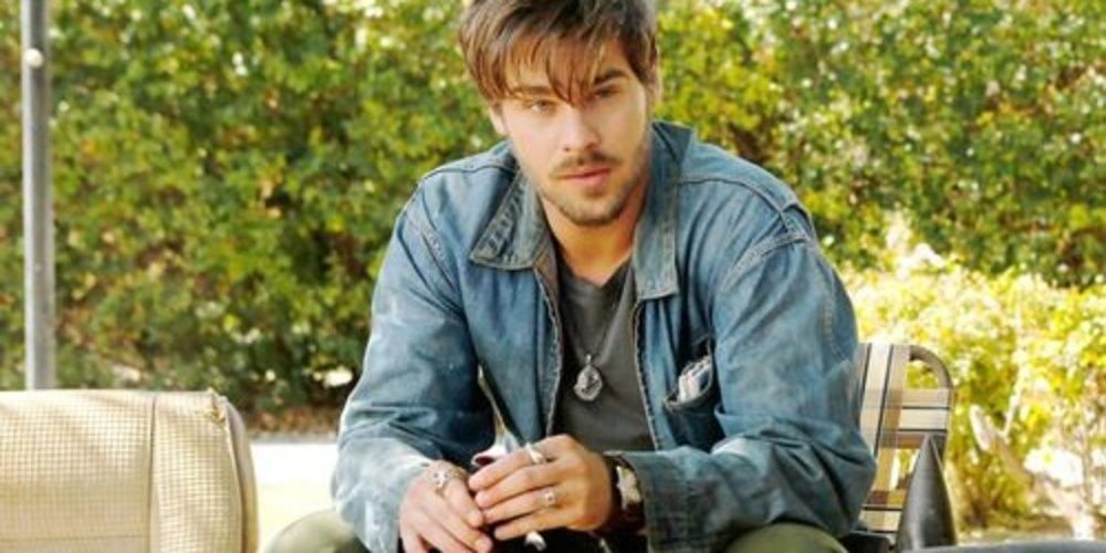 Grey Damon sitting on a chair in Aquarius