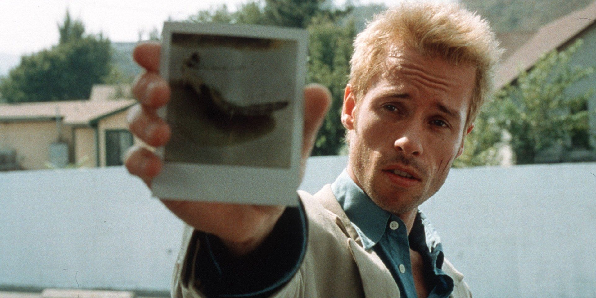 Guy Pearce segurando uma Polaroid em Memento
