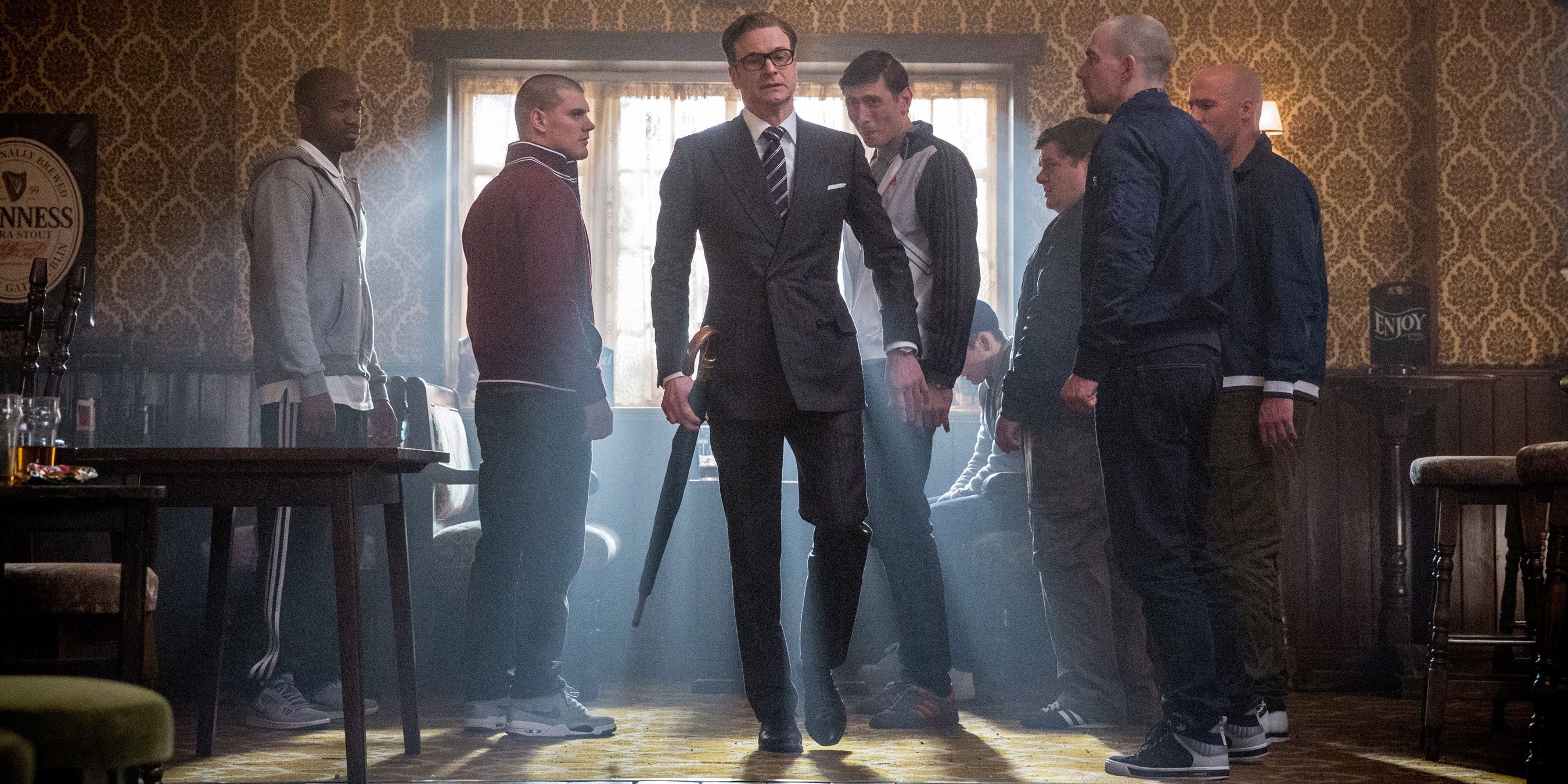 Harry Hart en un pub con hombres mirándolo con recelo en Kingsman The Secret Service