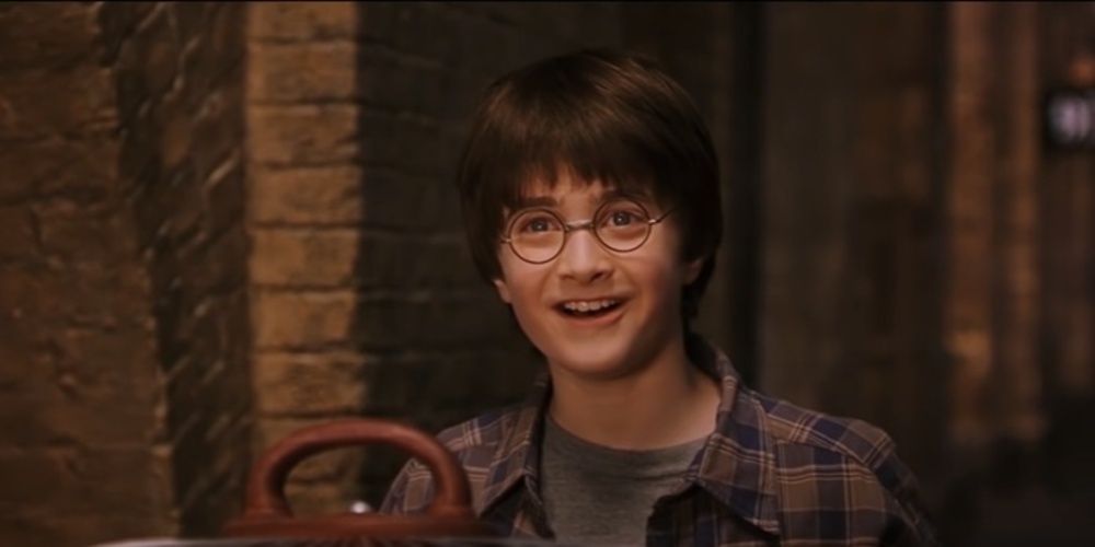 Harry olha para cima com um sorriso em Pedra Filosofal 