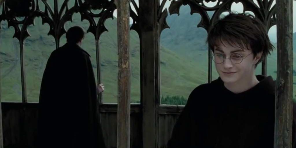 Harry sorri enquanto conversa com Lupin na ponte em Prisioneiro de Azkaban 