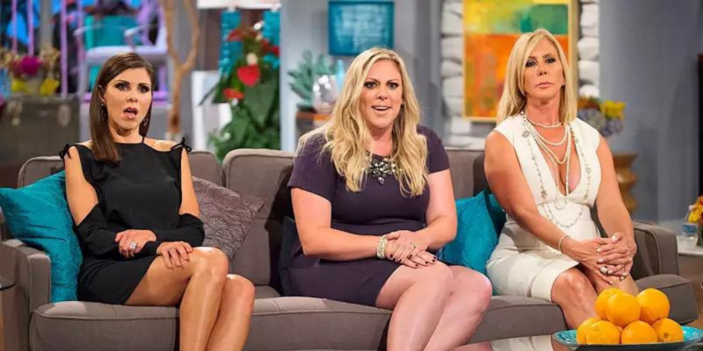 Heather, Brianna, and Vicki sit next to each other on the couch of a reunion for RHOC