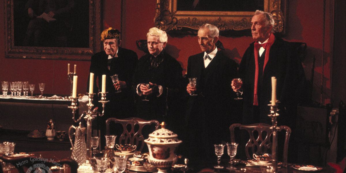 Vincent Price, Peter Cushing, John Carradine e Christopher Lee em pé com taças de vinho ao redor de uma elaborada mesa de jantar em House of the Long Shadows
