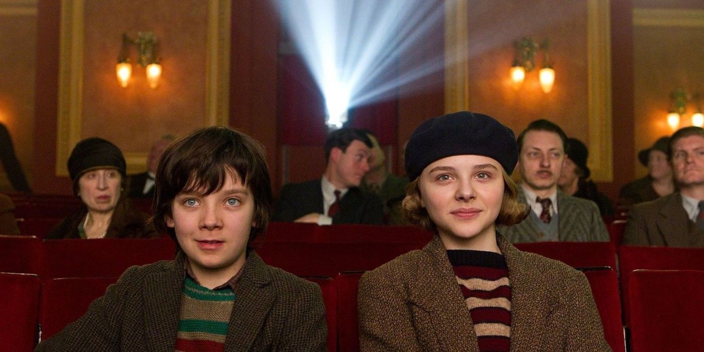 Asa Butterfield as Hugo Cabret and Chloë Grace Moretz as Isabelle sitting in a movie theater in Hugo