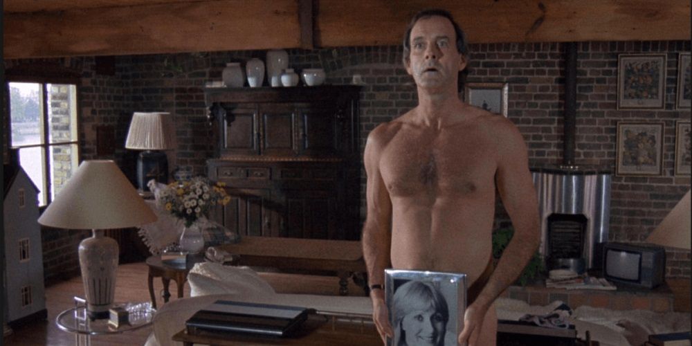 John Cleese covers himself up with a photo in A Fish Called Wanda