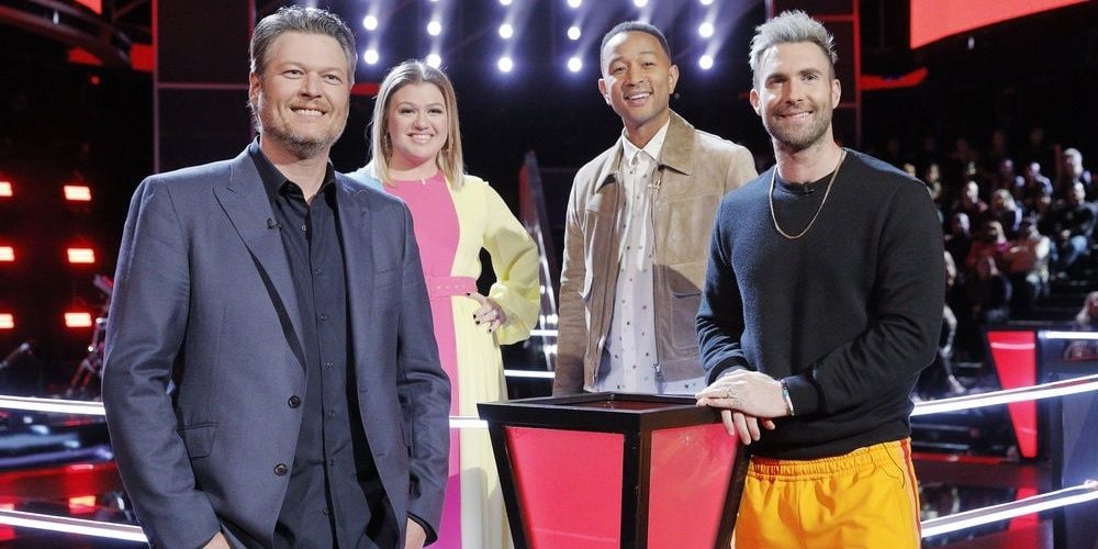 Judges stand on the stage and smile in The Voice