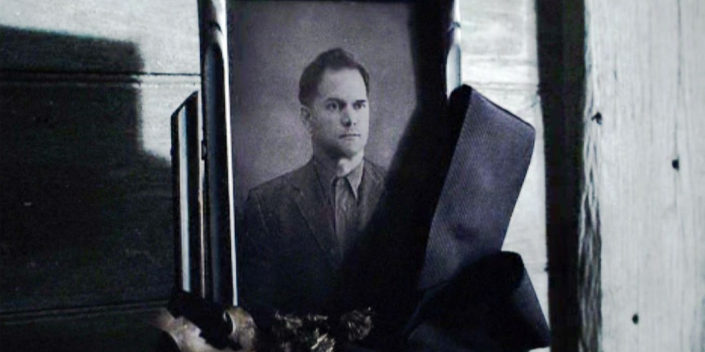 A framed photo of Katniss's father sitting in a cloak in The Hunger Games.