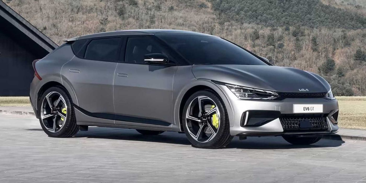 A silver Kia EV6 GT parked on a road with a mountainous background.