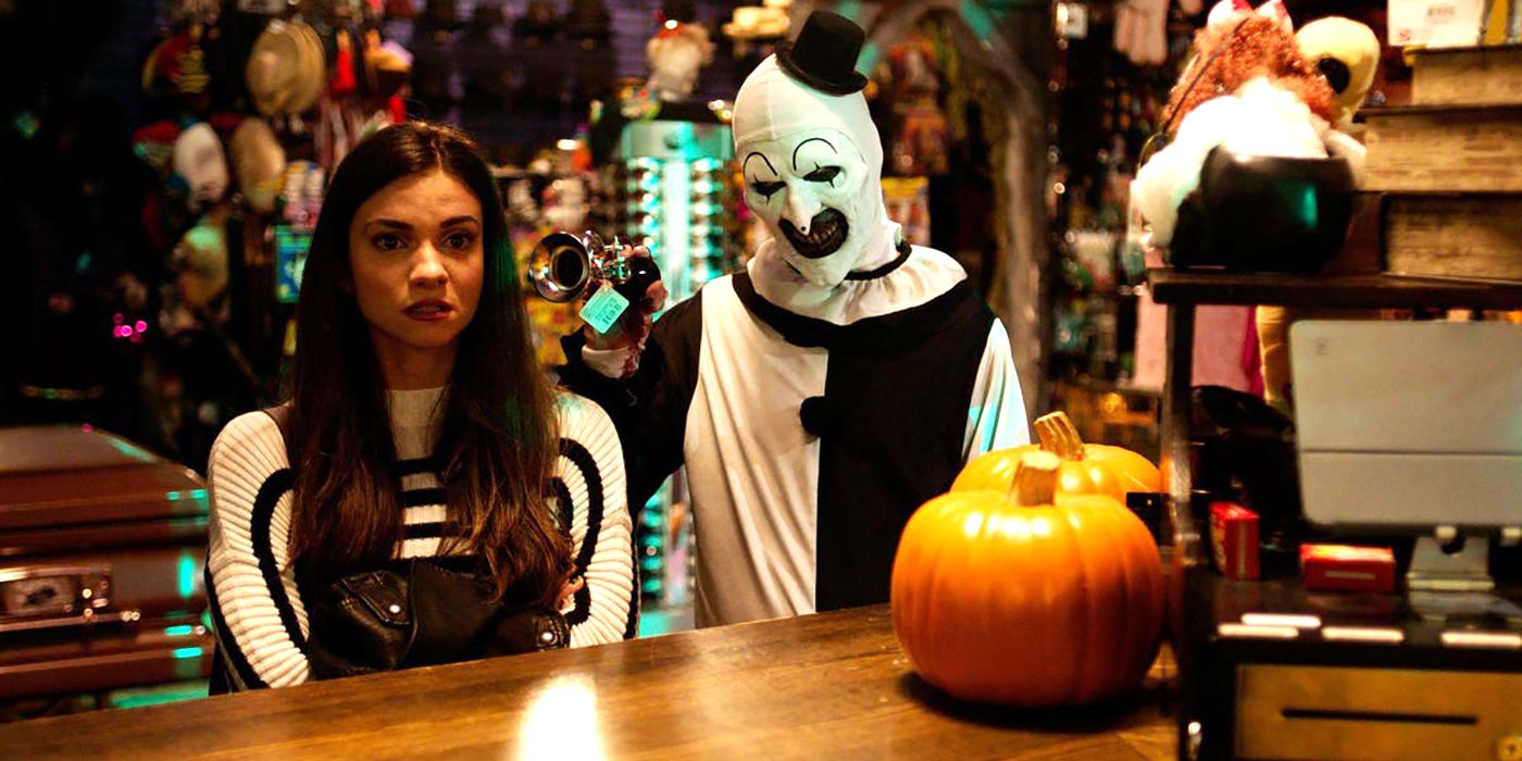 Art the Clown stands behind Lauren LeVara at a bar in Terrifier 2