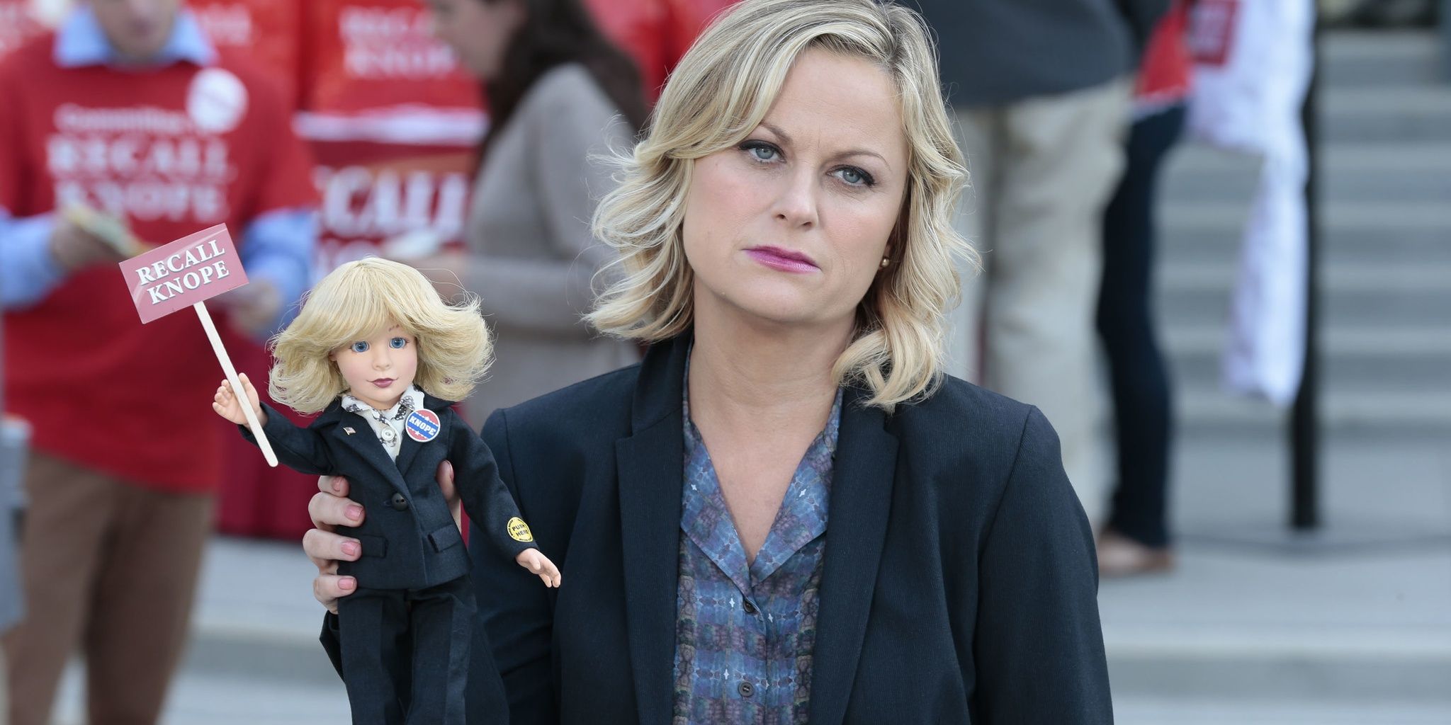Leslie holds up a doll in Parks and Recreation 