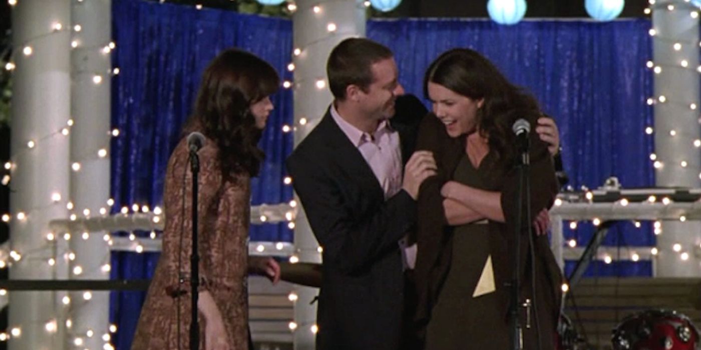 Rory and Chris pull Lorelai off the stage at Lane's wedding in Gilmore Girls. 