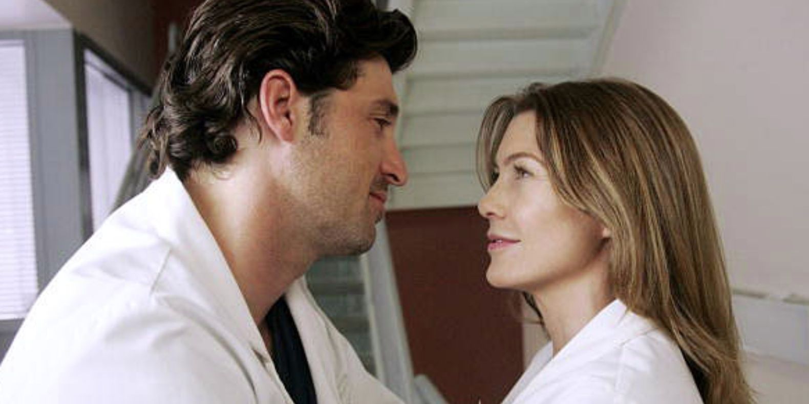 Meredith and Derek look at each other under the stairs in Grey&rsquo;s Anatomy