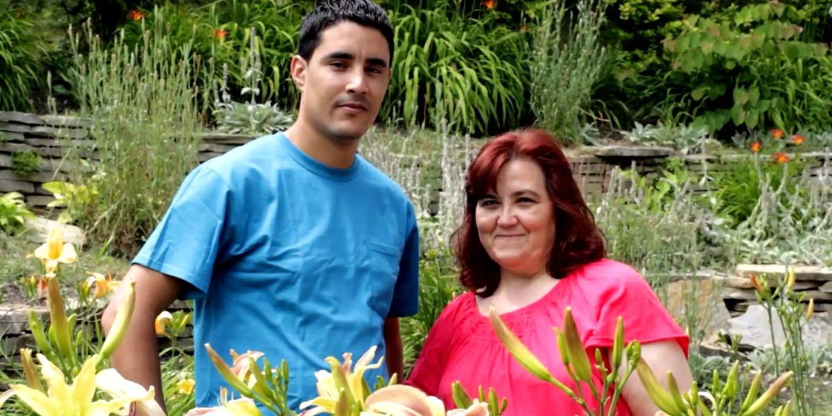 Mohamed and Danielle from 90 Day Fiance stand next to each other in a garden 