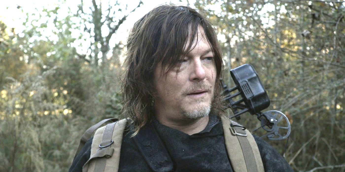 Norman Reedus as Daryl In The Walking Dead with greasy hair toting weapons through the scraggly woods