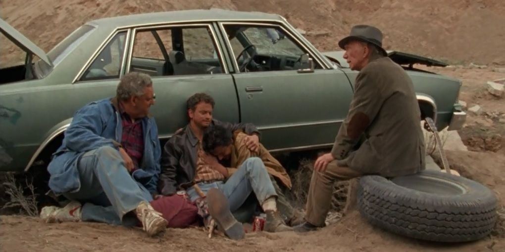 Post-apocalyptic survivors by a broken-down car in The Stand