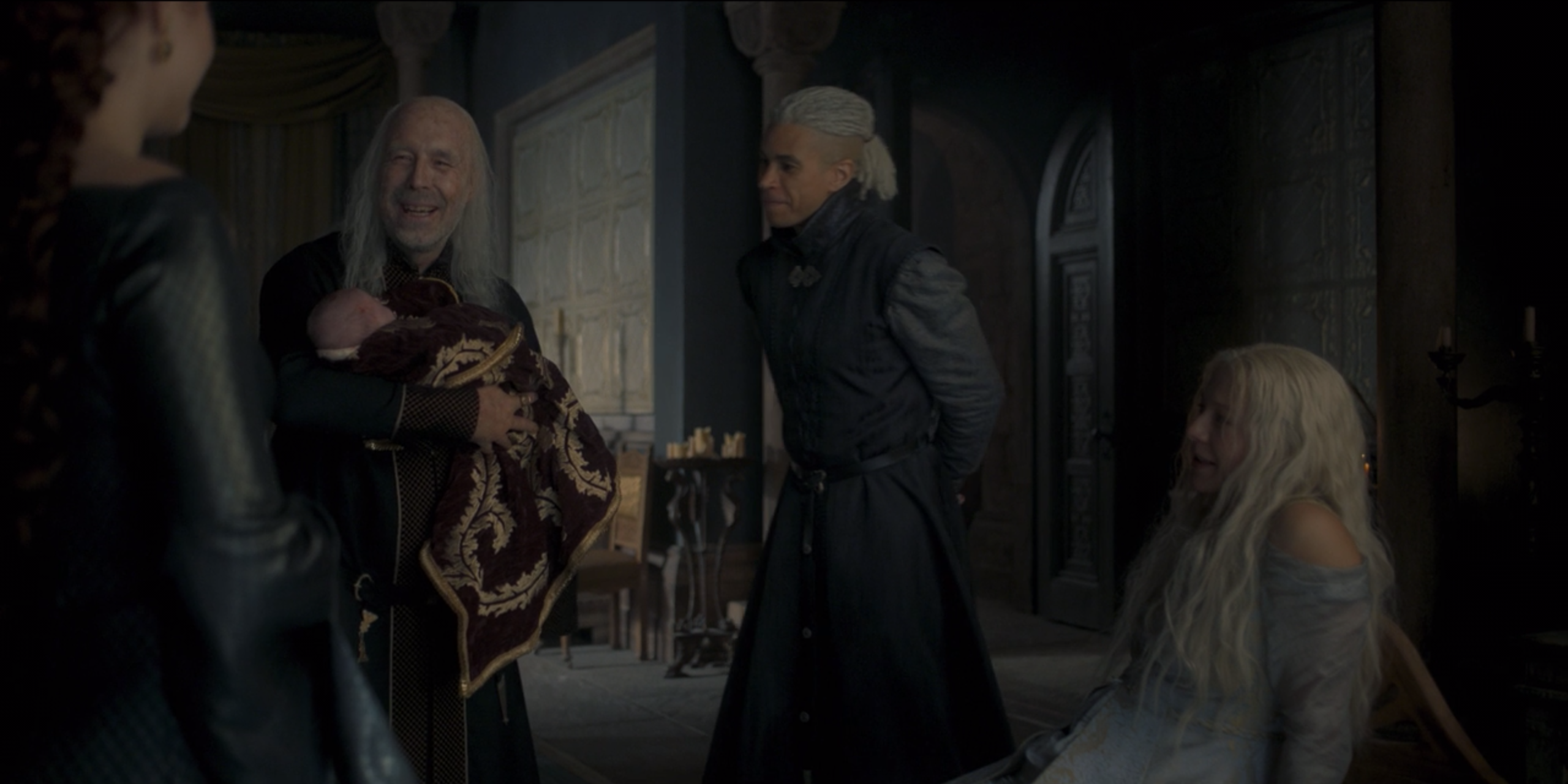 Viserys holds his third grandchild and smiles, surrounded by his family, on House of the Dragon