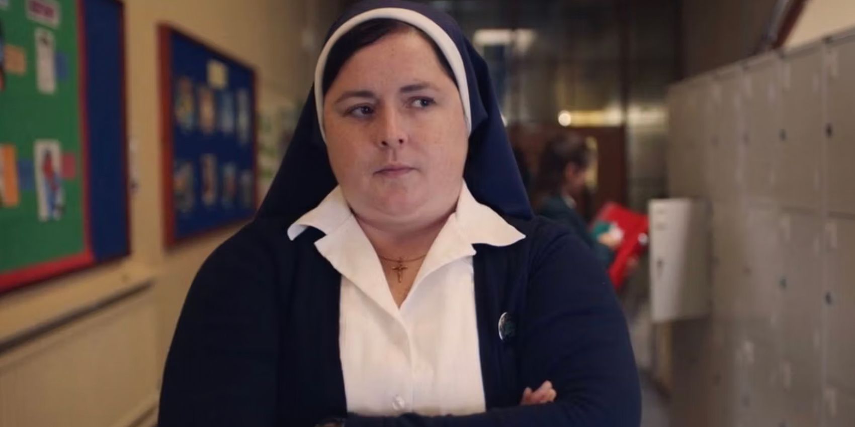 Sister Michael crosses her arms in the hallway at school in Derry Girls
