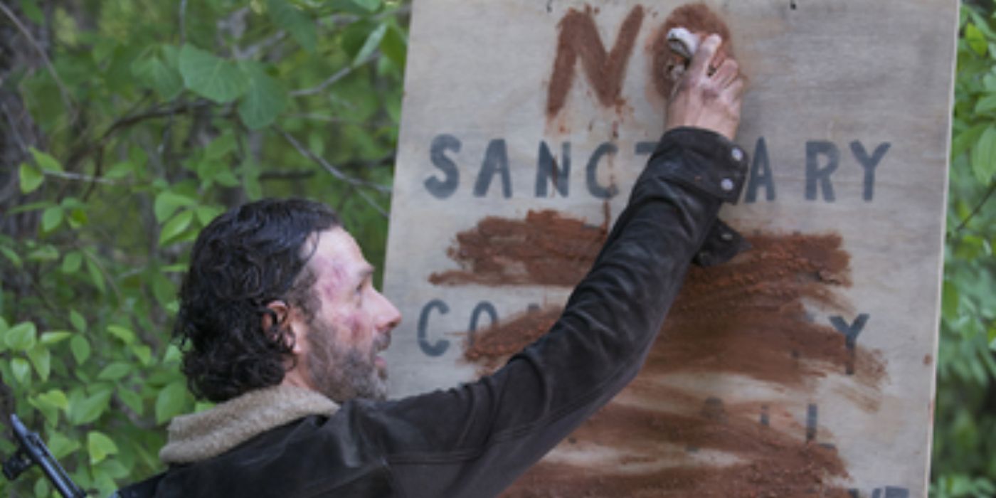 Rick writing on a Terminus sign in The Walking Dead. 
