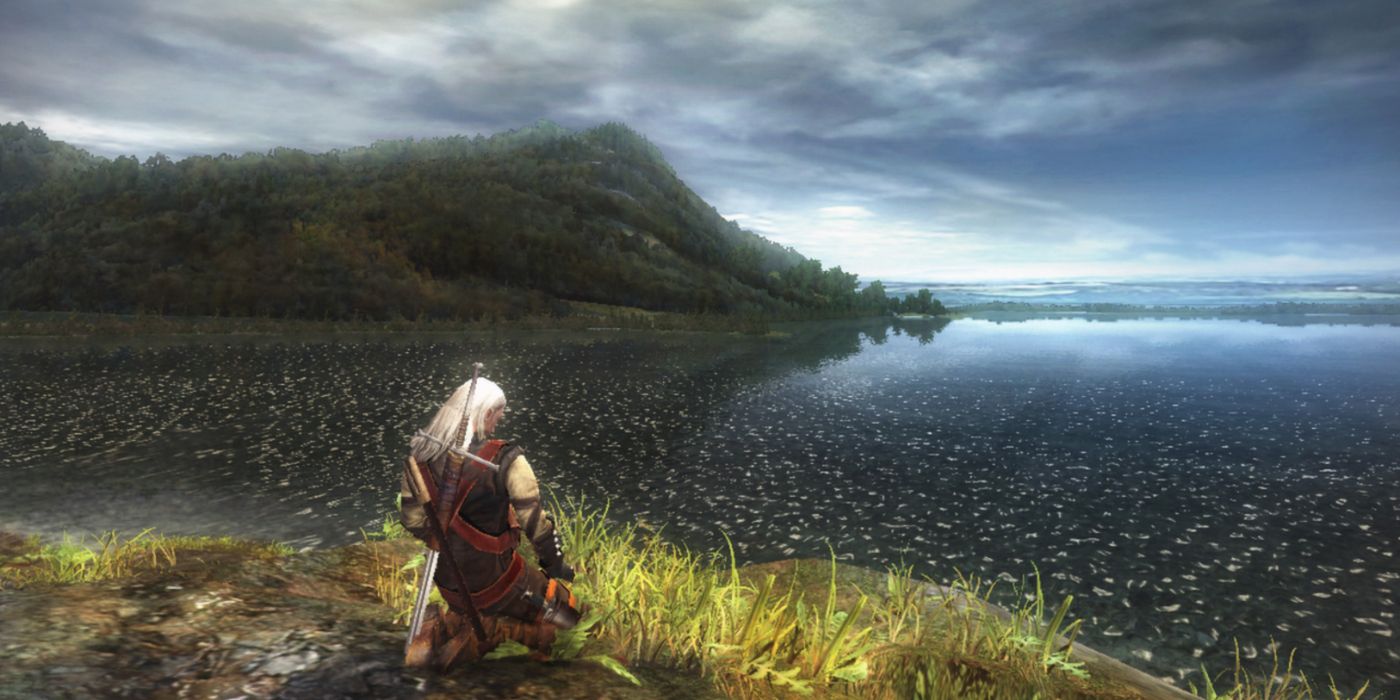 Geralt of Rivia meditating in front of a lake in The Witcher.