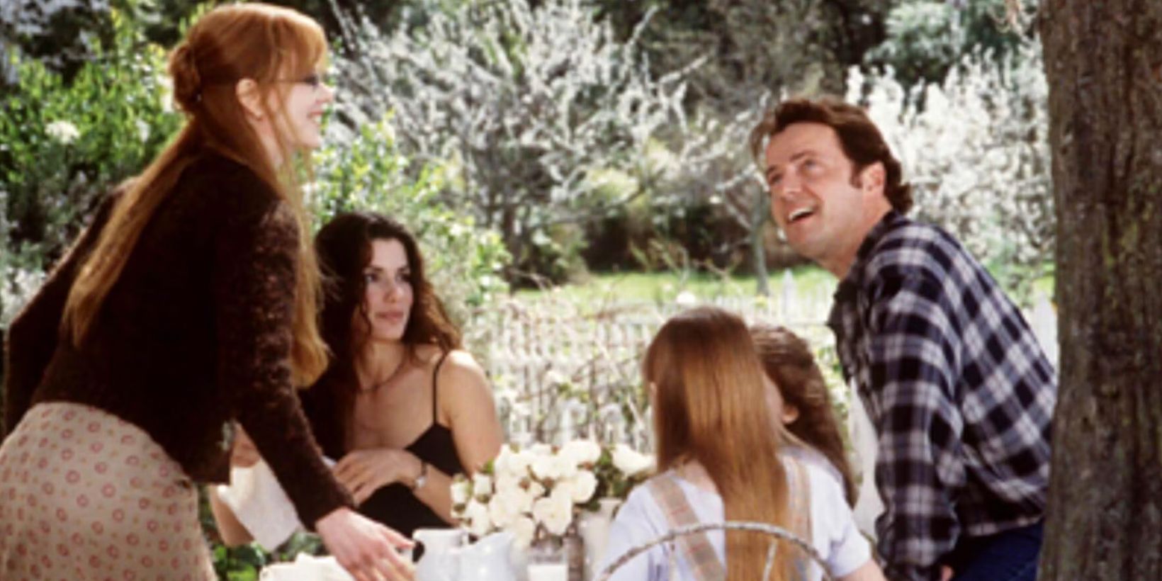 The family with the officer at breakfast outside in Practical Magic