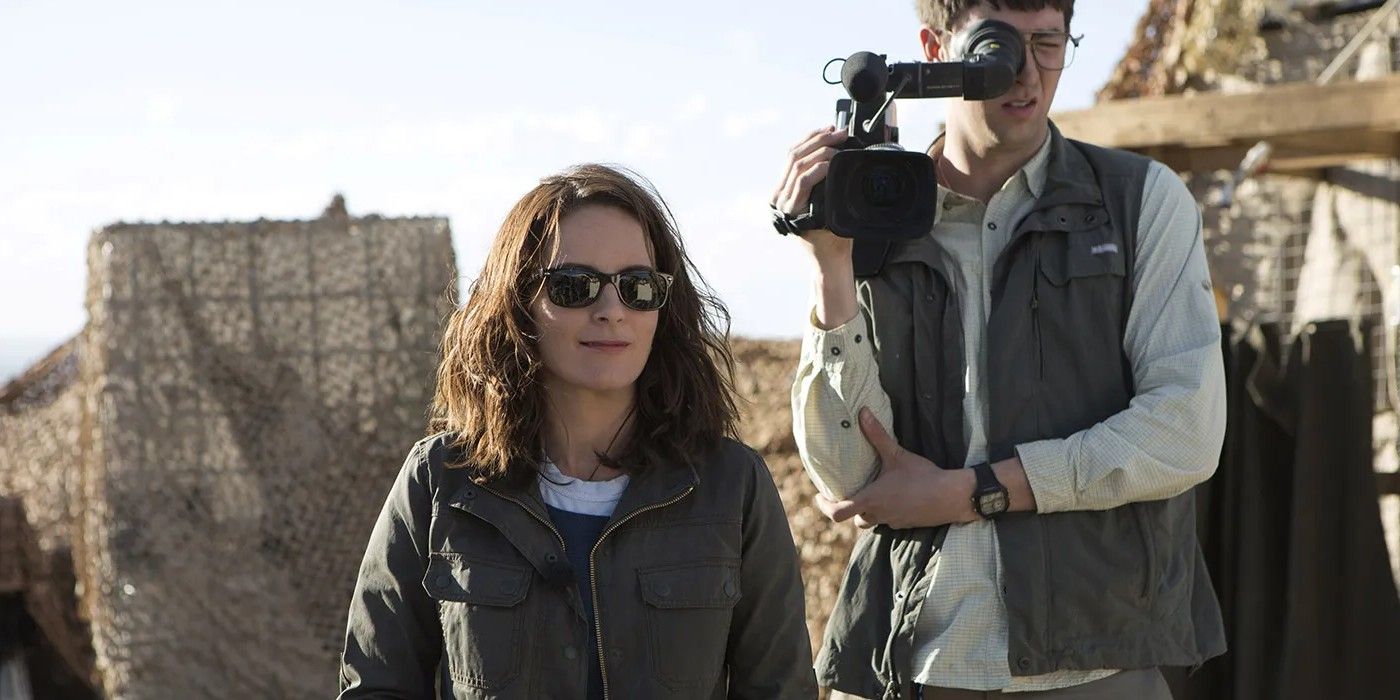Tina Fey wearing sunglasses with a camerman behind her in Whiskey Tango Foxtrot