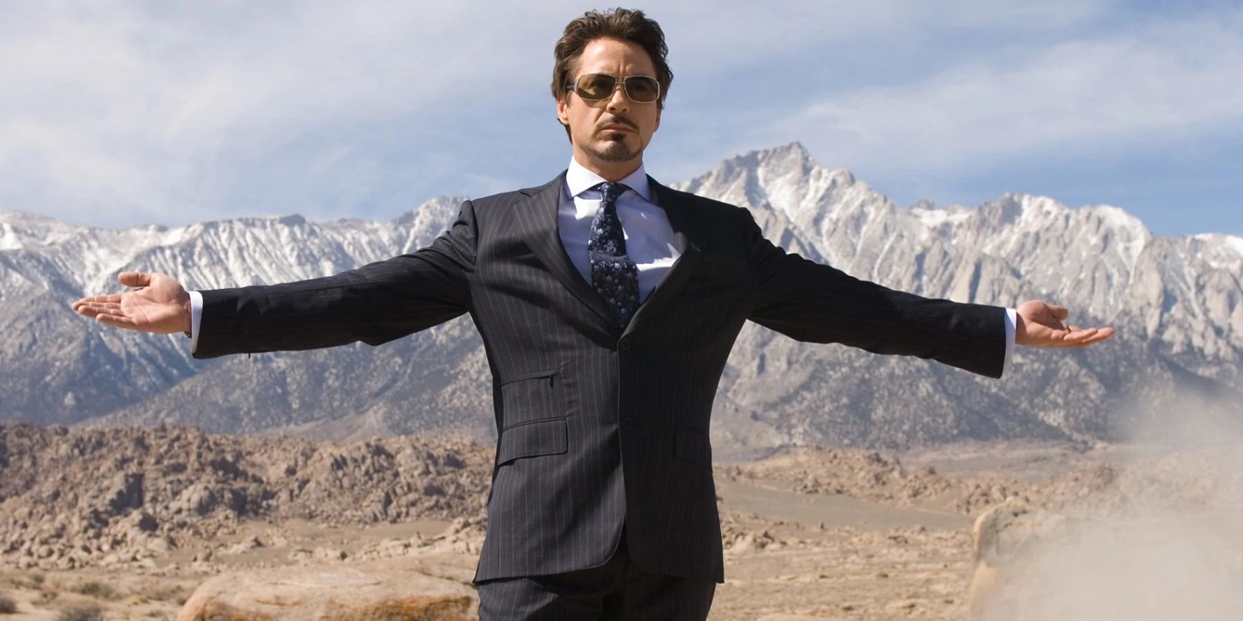 Tony Stark segurando seus braços no Afeganistão em Homem de Ferro.
