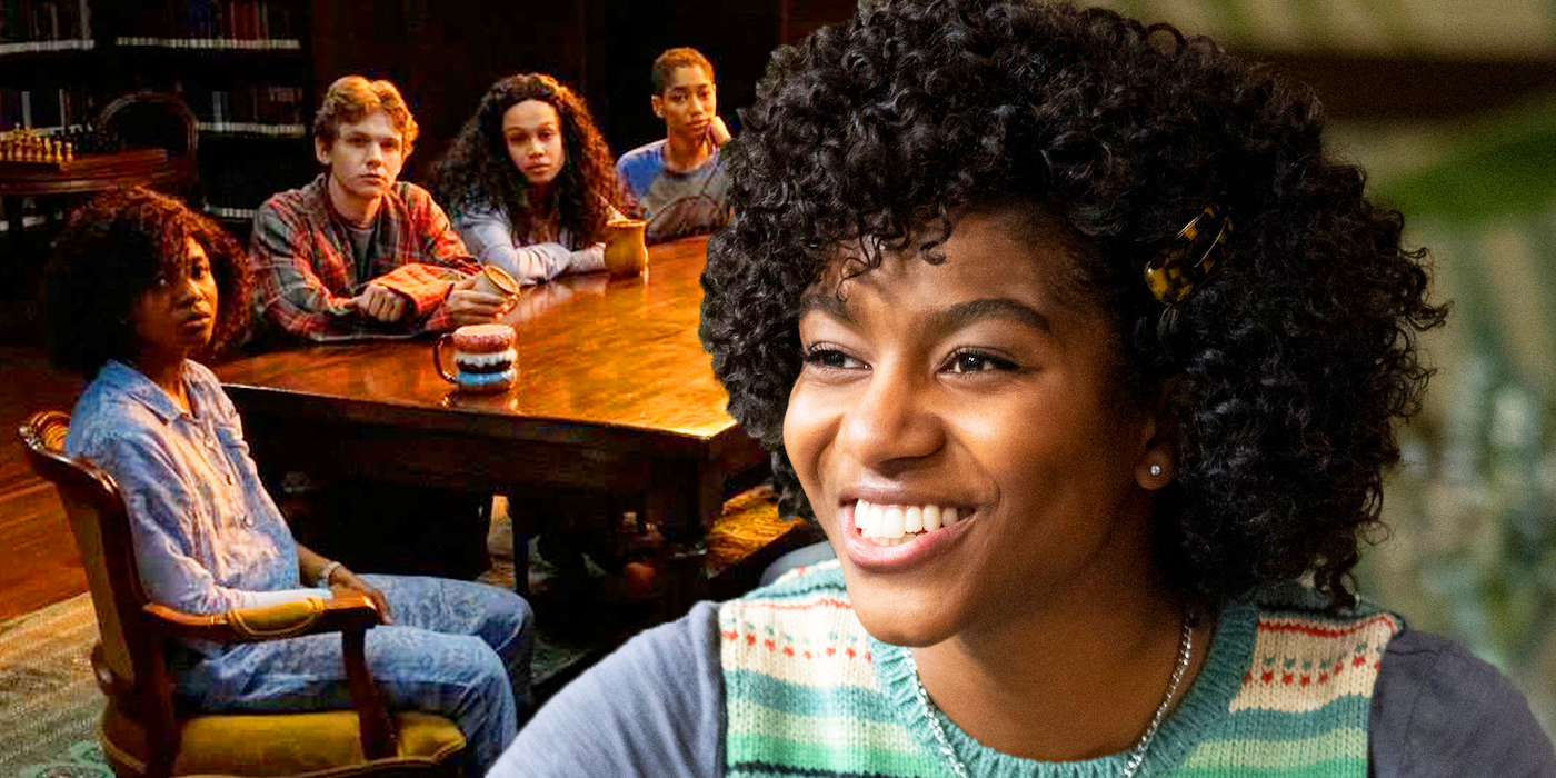 A Black girl with short, curly hair smiles at a group of teenagers gathered around a table.