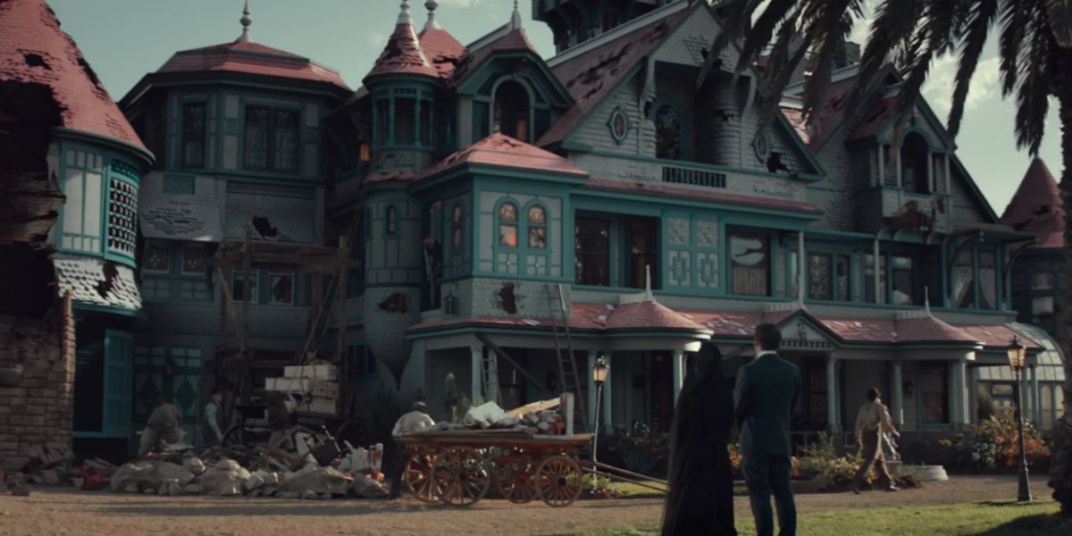 Sarah Winchester and Dr. Price standing in front of Winchester Mystery House undergoing construction