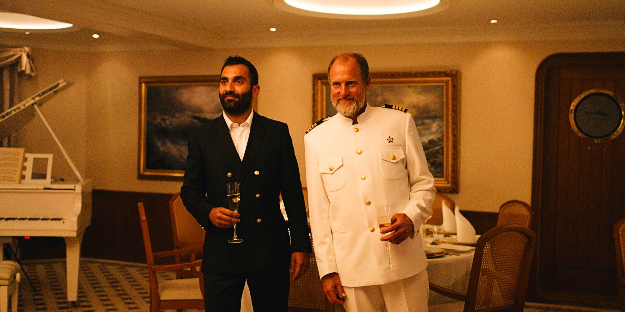 Woody Harrelson and Arvin Kananian smiling on a boat in Triangle of Sadness