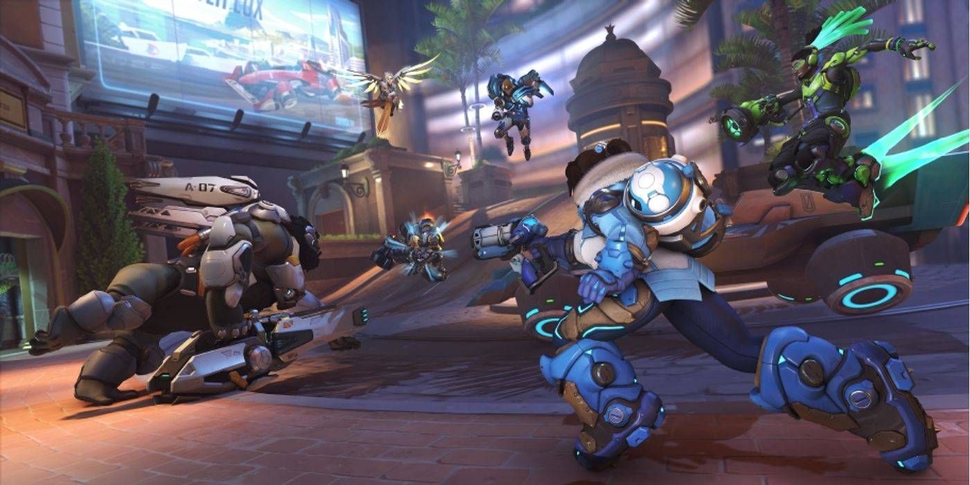 Overwatch 2 Team Versus Team Match com Winston, Lucio, Mei, Mercy, Pharah e Reinhardt atacando perto do objetivo