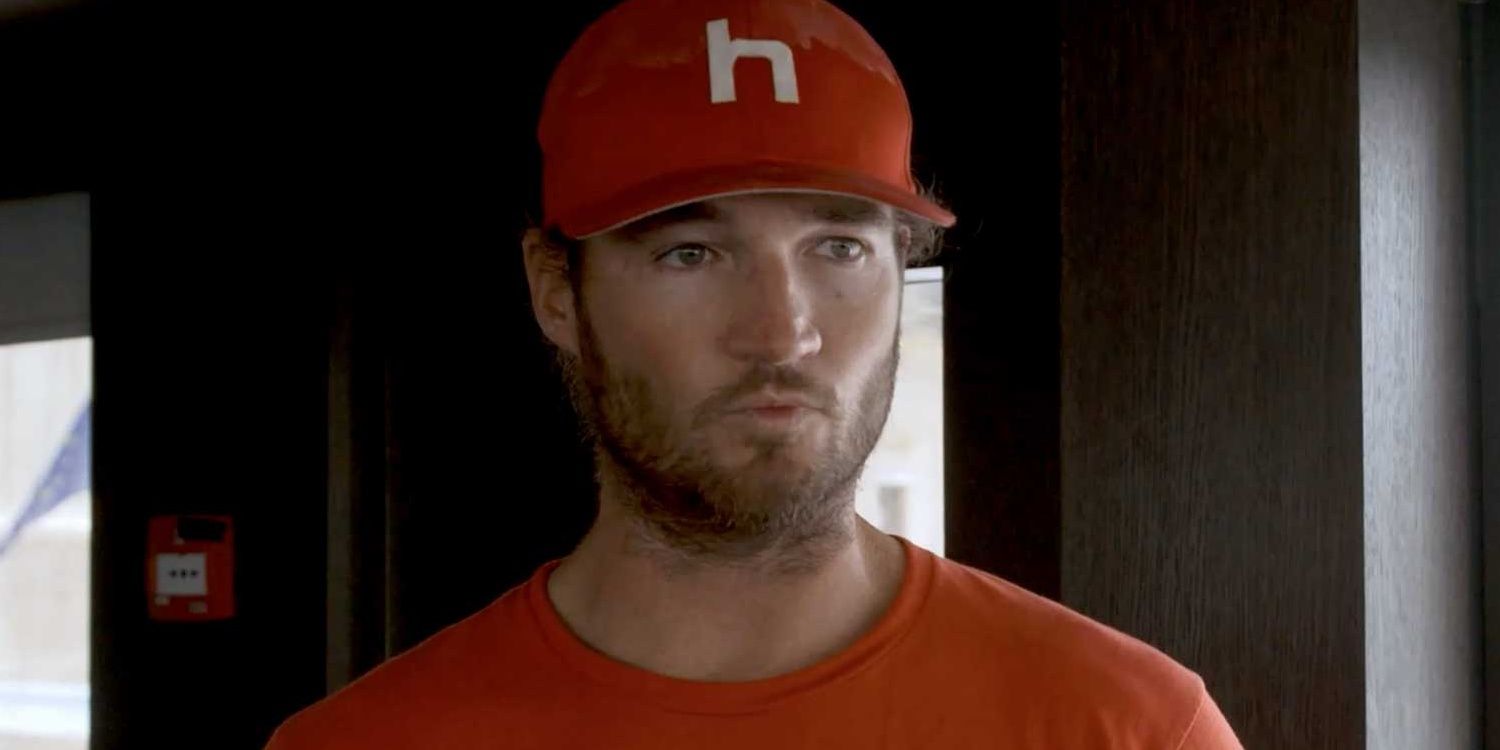 Jason Gaskell purses lips, wearing red hat and shirt