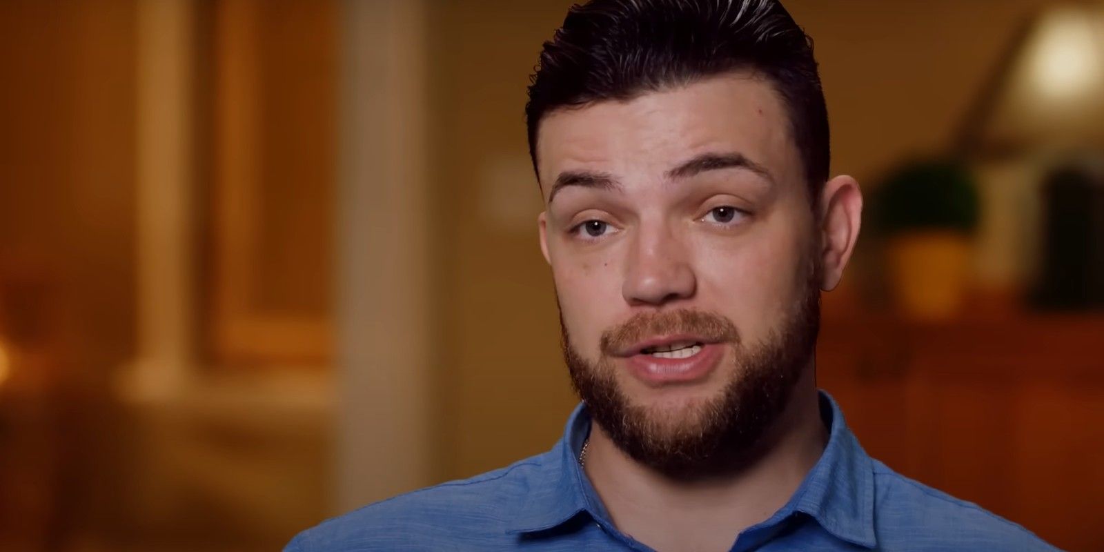 90 Day Fiancé's Andrei Castravet in a blue shirt looking at camera