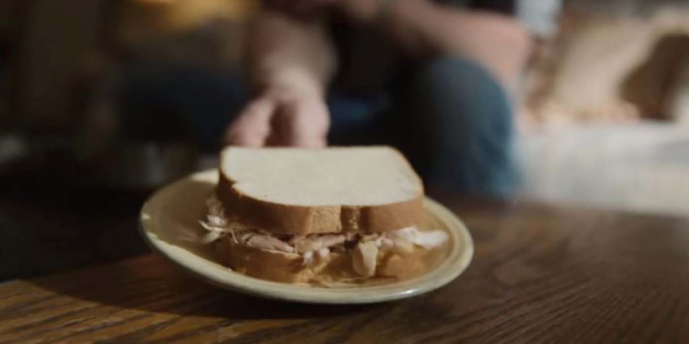 A close up of the meat sandwich on a table in Monster: The Jeffrey Dahmer Story