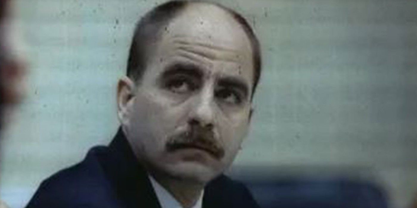 A balding man with light brown hair and a moustache in a dark blue suit.