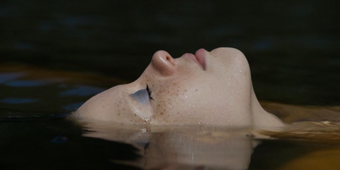 Mia Goth as Maxine floats face-up in a lake in X