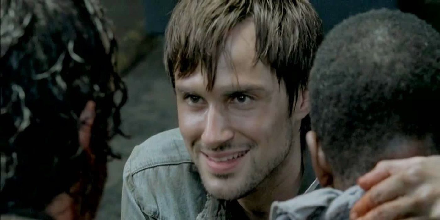 Gareth smiling with his arm around someone's neck in a scene from The Walking Dead.