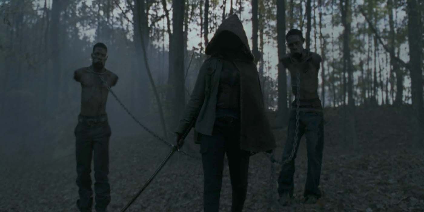 Michonne com sua capa, katana e animais de estimação walker em The Walking Dead.