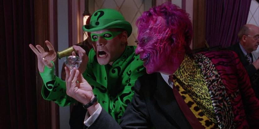 Two Face (Tommy Lee Jones) holding a diamond in front of Riddler (Jim Carrey) in Batman Forever