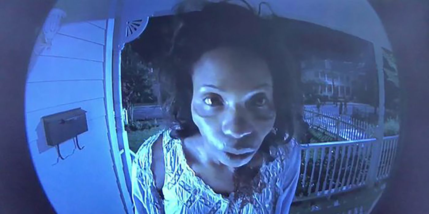 A fisheye view of Morgan's undead wife staring into the home's peephole in The Walking Dead.